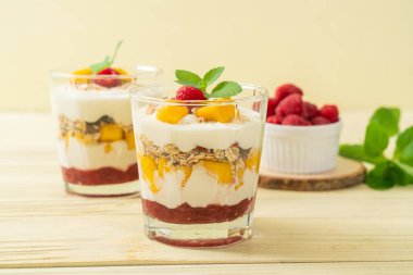 Ev yapımı taze mango ve yoğurt ve granola ile taze ahududu. Sağlıklı yemek tarzı.