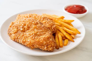 Kızarmış tavuk göğsü fileto biftek yanında patates kızartması ve ketçap.