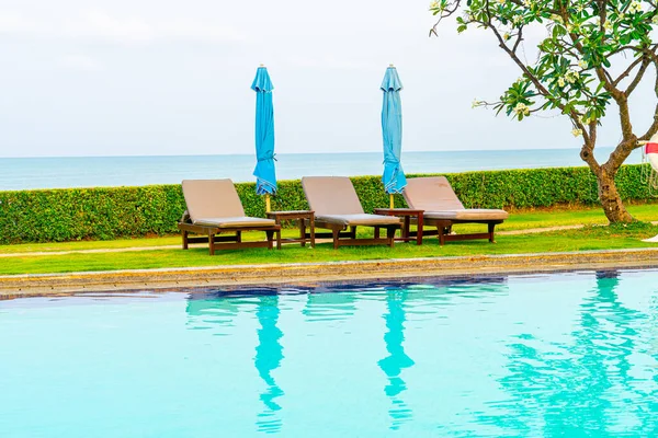 Sandalye havuzu ya da yüzme havuzu etrafında şemsiye olan yatak havuzu