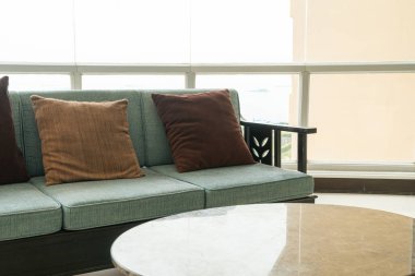 Boş kanepe ve yastıklı sandalye bir odada.