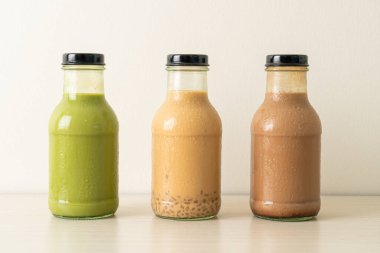 Kibrit yeşil çay latte, çikolata ve sütlü çay masada cam şişede puding jölesi