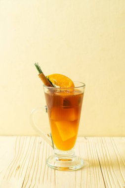 Bir bardak buzlu americano sade kahve ve biberiye ve tarçınla süslenmiş portakal ve limon suyu.