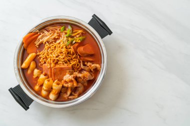 Budae Jjigae ya da Budaejjigae (ordu yahnisi ya da ordu üssü). Kimchi, konserve jambon, sosis, ramen eriştesi ve çok daha popüler Kore usulü sıcak yemek ile dolu.