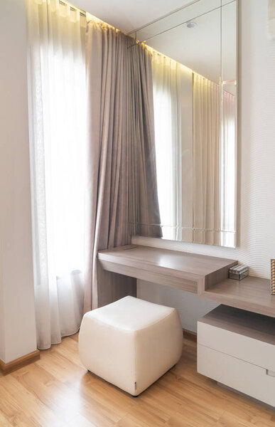 empty dressing table with mirror and curtain in bedroom