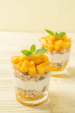 Taze mangolu yoğurt ve camlı granola. Sağlıklı yemek tarzı.