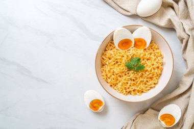 Hazır erişte kasesi ve tuzlu yumurta.