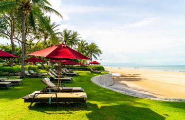 Tatil seyahati konsepti için otel tatil beldesinde deniz manzaralı bir şemsiye ve sandalye.