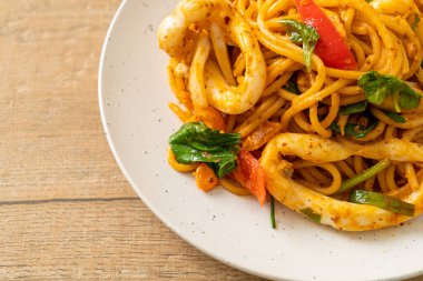 Kızarmış spagetti, tuzlanmış yumurta ve kalamar. Füzyon yemek stili.