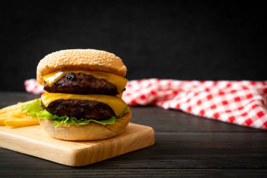Peynirli ve patates kızartmalı hamburger veya sığır burger. Sağlıksız yemek tarzı.