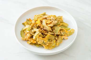 Kızarmış acı kabağı tabakta yumurta ile karıştır