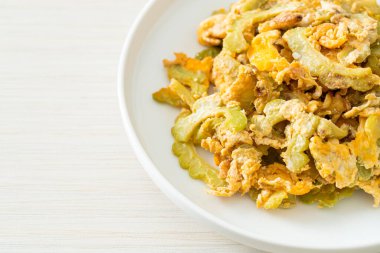 Kızarmış acı kabağı tabakta yumurta ile karıştır