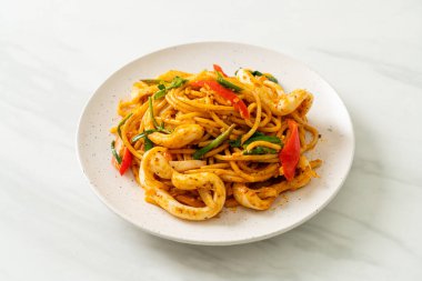 Kızarmış spagetti, tuzlanmış yumurta ve kalamar. Füzyon yemek stili.