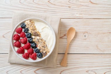 Ev yapımı yoğurt kasesi, ahududu, yaban mersini ve granola. Sağlıklı yemek tarzı.