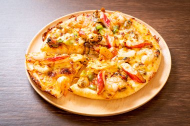 Tahta tepside deniz ürünleri (karides, ahtapot, midye ve yengeç) pizza