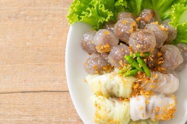 Şeffaf toplara Saku Sai Moo ya da Buharlı Tapioca Köfte Topları ve (Kow Griep Pag Mor) Domuz Buharlı Pirinç Paketleri ya da Haşlanmış Pirinç Kabuklu Mantı denir.