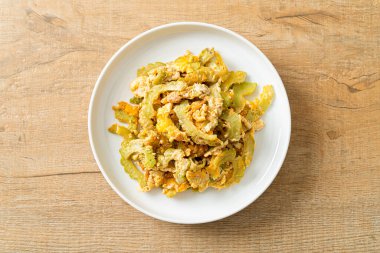 Kızarmış acı kabağı tabakta yumurta ile karıştır