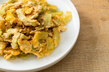 Kızarmış acı kabağı tabakta yumurta ile karıştır