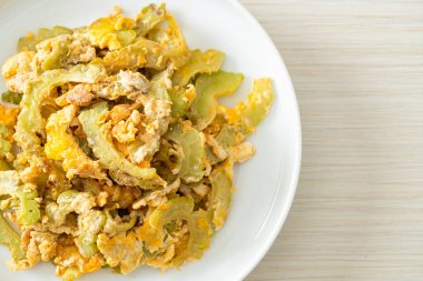 Kızarmış acı kabağı tabakta yumurta ile karıştır