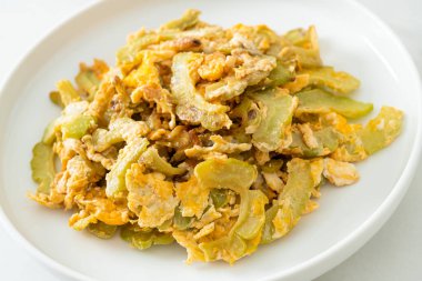 Kızarmış acı kabağı tabakta yumurta ile karıştır