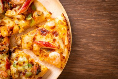 Tahta tepside deniz ürünleri (karides, ahtapot, midye ve yengeç) pizza