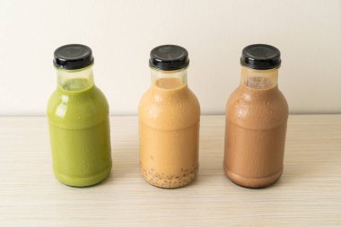 Kibrit yeşil çay latte, çikolata ve sütlü çay masada cam şişede puding jölesi