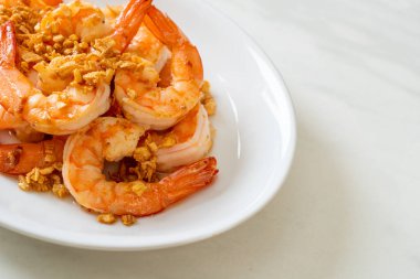 Kızarmış karides ya da beyaz tabakta sarımsaklı karides - deniz ürünleri tarzı.