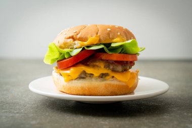 Beyaz tabakta peynirli domuz burger.