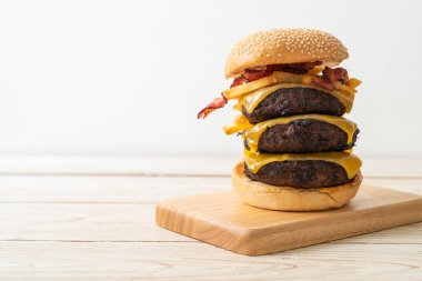 Peynirli hamburger, domuz pastırması ve patates kızartması. Sağlıksız yemek tarzı.