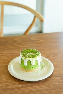 Cafe restoranındaki masada kibrit yeşil çay peynirli kek.