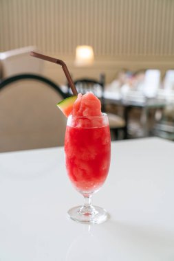 Kafe restoranındaki masada taze karpuz suyu bardağı var.