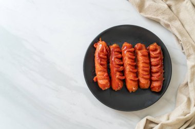 Siyah tabakta kızarmış sosis şişi.