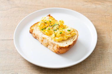 Ekmek tostu, çırpılmış yumurta ve beyaz tabak.