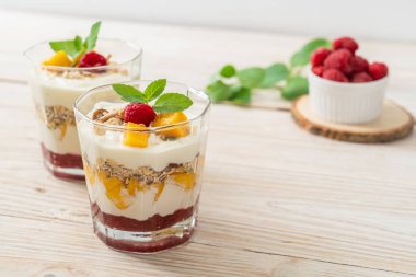 Ev yapımı taze mango ve yoğurt ve granola ile taze ahududu. Sağlıklı yemek tarzı.