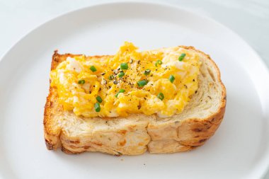 Ekmek tostu, çırpılmış yumurta ve beyaz tabak.