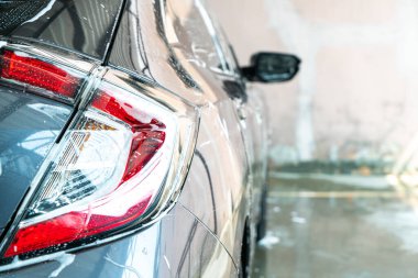 Araba yıkama köpüğüyle yakın plan araba farları.