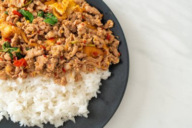 Pirinçli yumurta ve fesleğenli kızarmış domuz eti. Asya usulü.