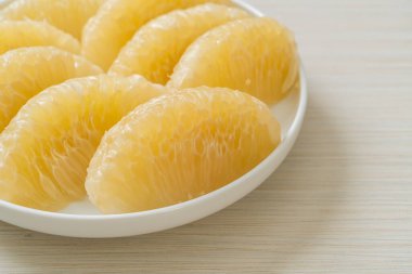 Taze soyulmuş zeytin, greyfurt ya da beyaz tabakta Shaddock.