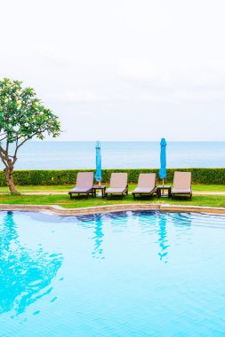 Sandalye havuzu ya da yüzme havuzu etrafında şemsiye olan yatak havuzu