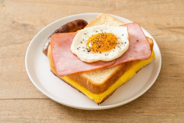 Ev yapımı kızarmış peynir üzerine jambon ve kahvaltıda domuz sosisli sahanda yumurta.