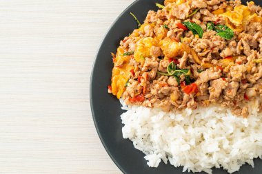 Pirinçli yumurta ve fesleğenli kızarmış domuz eti. Asya usulü.