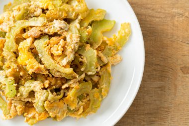 Kızarmış acı kabağı tabakta yumurta ile karıştır