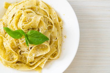 Pesto fettuccine makarna, üstüne de parmesan peyniri.