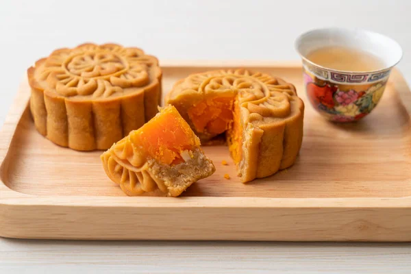 Chinese moon cake durian and egg yolk flavour with tea on wood plate