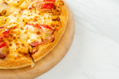 jambonlu ve yengeçli pizza veya Hawaii pizzası.