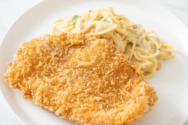 Ev yapımı spagetti makarna beyaz krema sosu ve kızarmış balık.