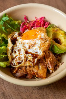 Kızarmış tavuk teriyaki soslu pilav ve avokado ve sahanda yumurta. Füzyon yiyecekler.