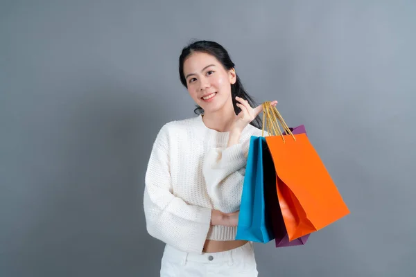 Schöne Junge Asiatin Mit Einkaufstaschen Auf Grauem Hintergrund — Stockfoto