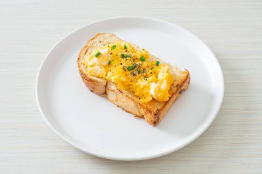 Ekmek tostu, çırpılmış yumurta ve beyaz tabak.