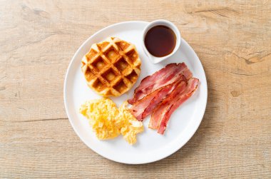 Kahvaltı için çırpılmış yumurta, pastırma ve waffle.