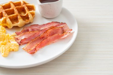 Kahvaltı için çırpılmış yumurta, pastırma ve waffle.